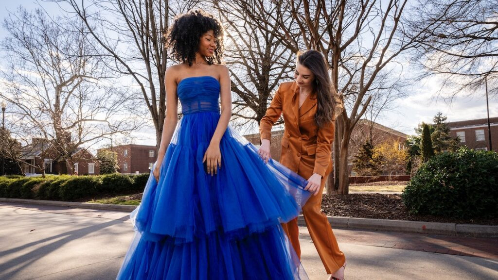 Fashion student posing with model wearing her design at UNCG