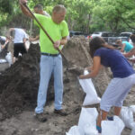 People shoveling sand into sandbags