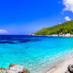 Turquoise waters and lush greenery at Kastani Beach, Skopelos, Greece, a key filming location for the movie Mamma Mia!