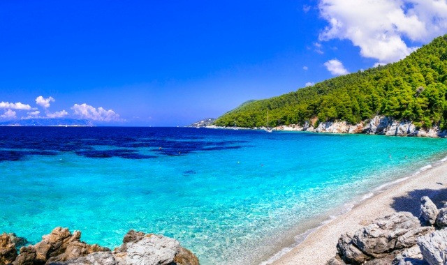 Turquoise waters and lush greenery at Kastani Beach, Skopelos, Greece, a key filming location for the movie Mamma Mia!