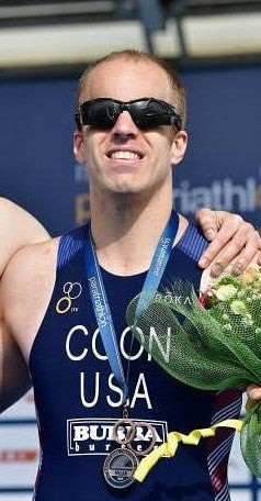 Kyle Coon poses with a medal around his neck.