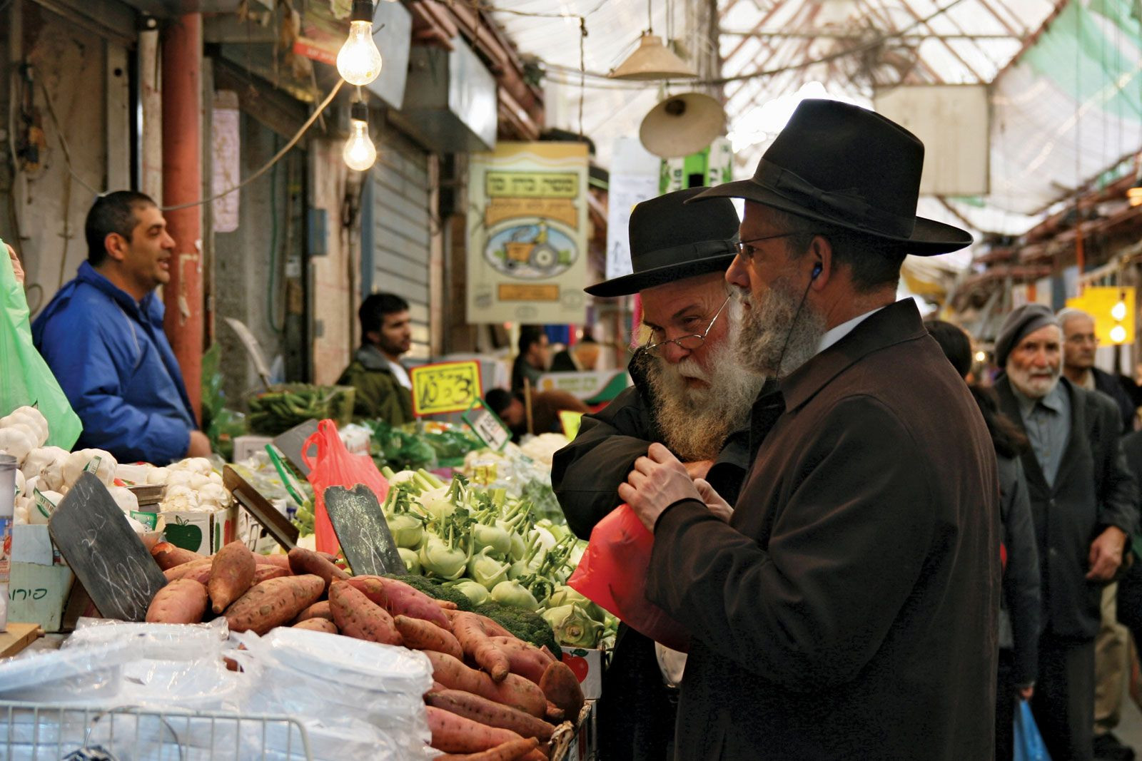 A bustling market scene in Jerusalem's Mahane Yehuda Market, showcasing the vibrant daily life and cultural diversity of the city.
