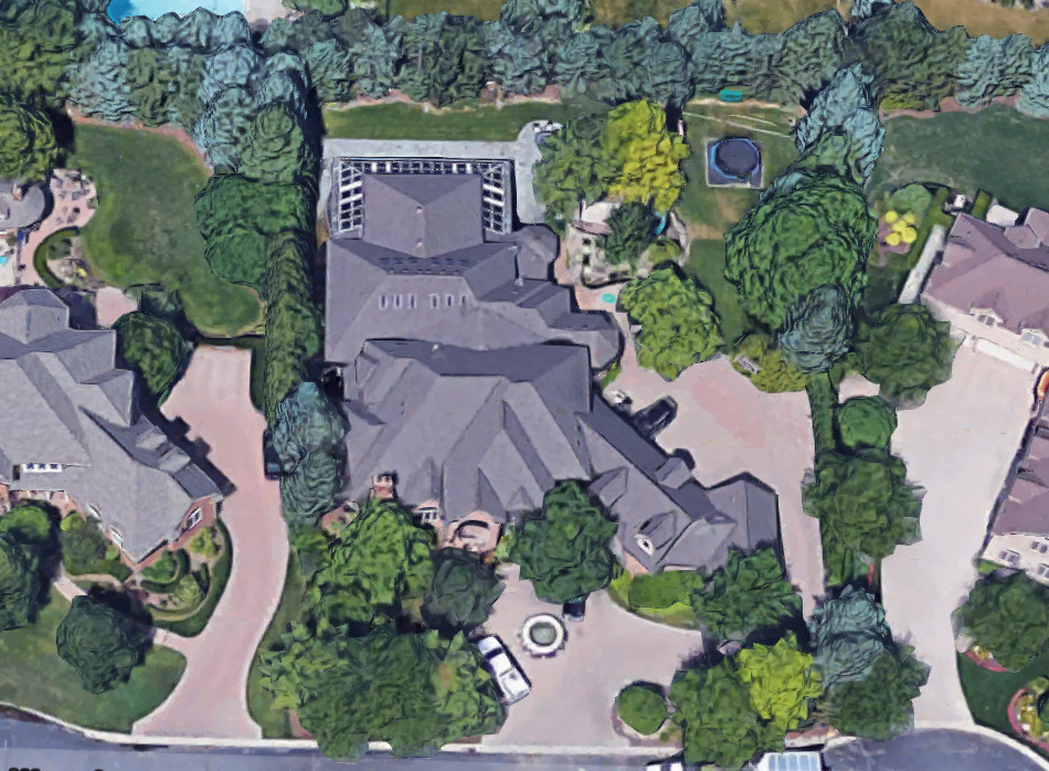 Exterior view of Eminem's Detroit mansion featuring a brick facade and fountain in the driveway