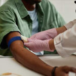 Nurse taking blood sample from senior patient