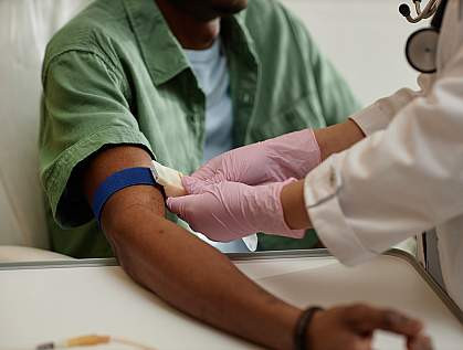 Nurse taking blood sample from senior patient