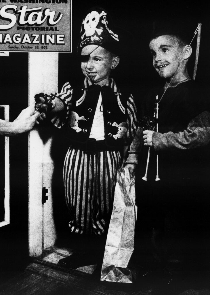 Image of children trick-or-treating in costume, illustrating the quintessential modern Halloween tradition of trick-or-treating for candy.