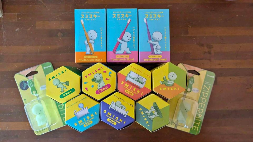 A collection of Smiski Bath Series figurines arranged on a blue tiled surface, highlighting their playful poses.
