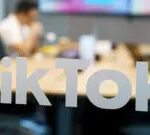 TikTok logo on a smartphone screen in front of the Capitol Building, illustrating concerns about national security