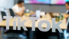 TikTok logo on a smartphone screen in front of the Capitol Building, illustrating concerns about national security