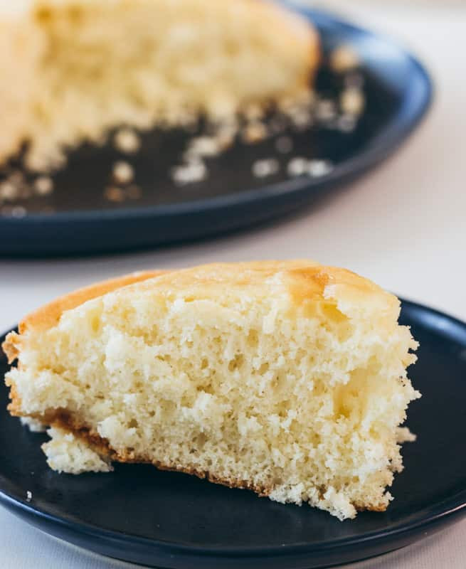 Close up of vanilla yellow cake on navy plate.