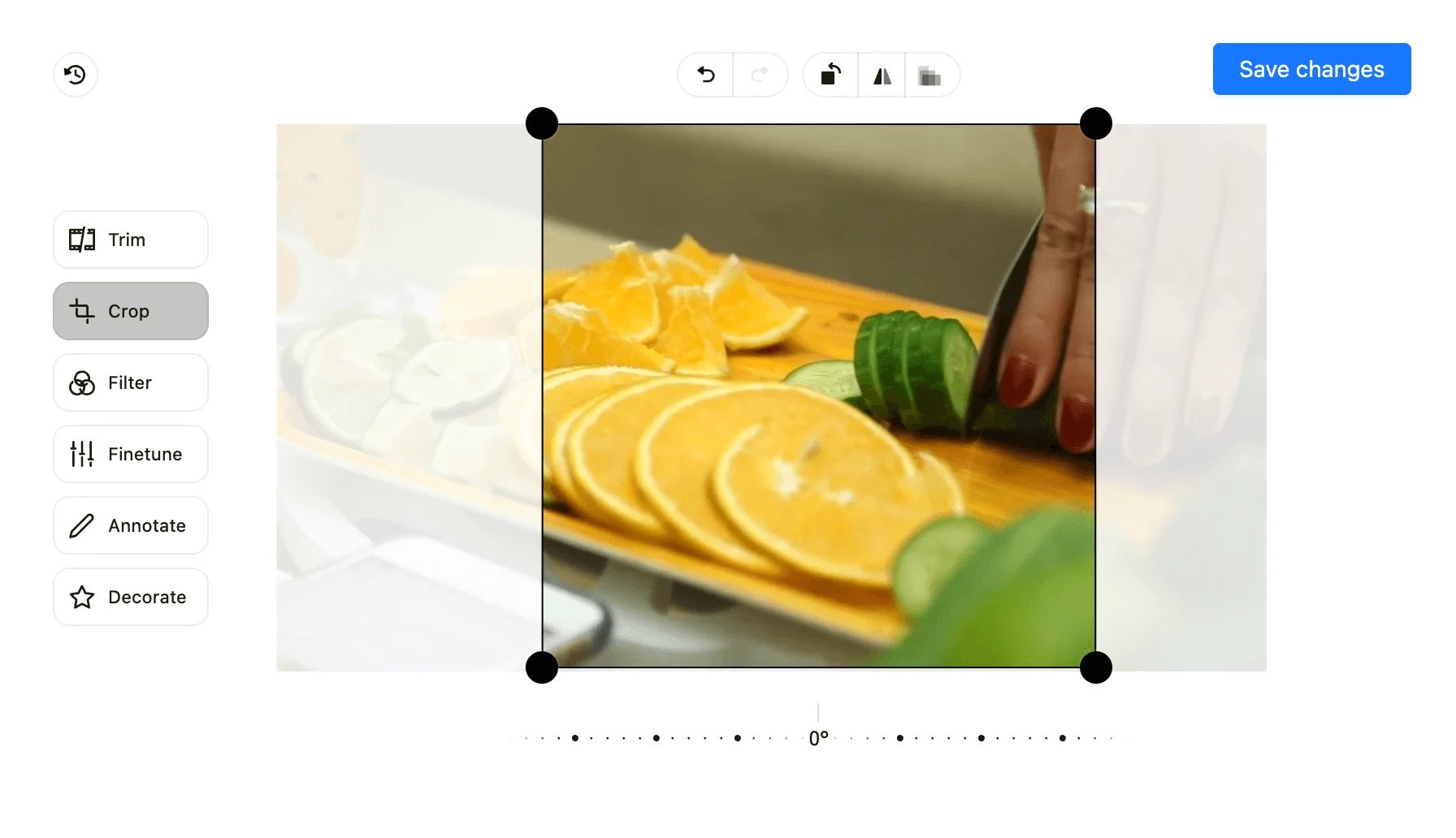 Planable's image and video editing interface, showing cropping tools on a photo of oranges and cucumbers.